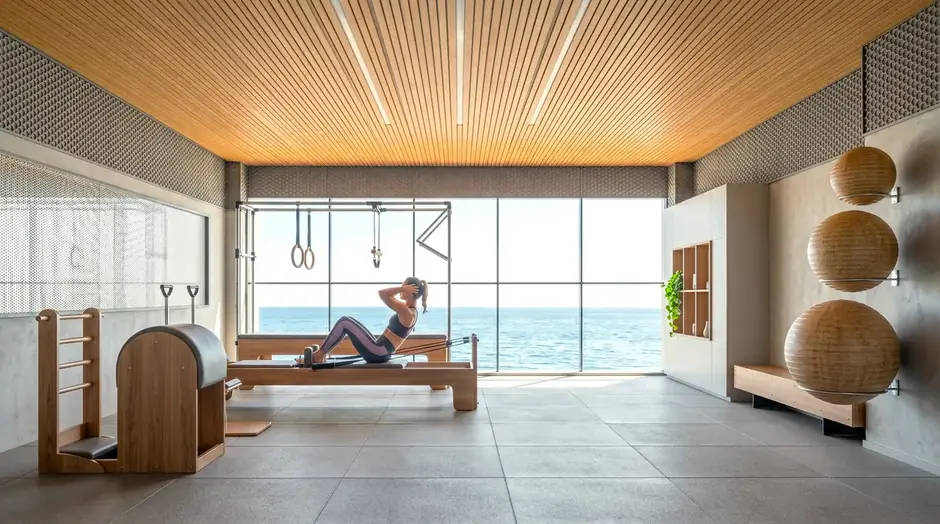 Sala de pilates com aparelhos e vista para o mar
