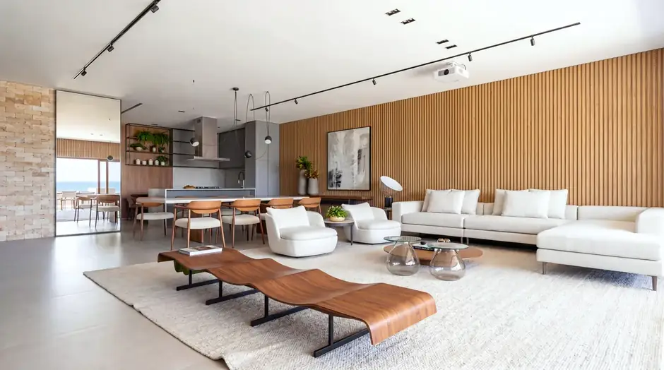 Sala de estar integrada do apartamento de 274 m² com painel ripado e vista para o mar