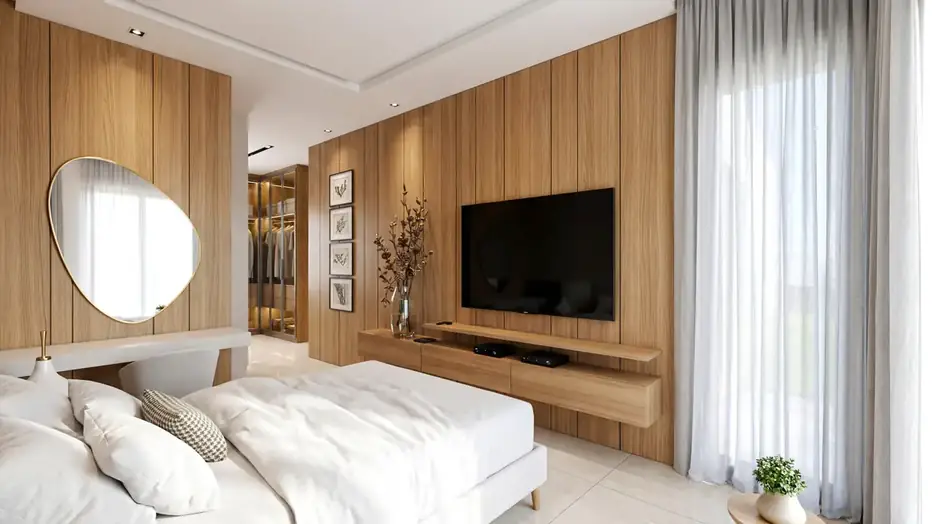 Suíte master do apartamento lateral com painel de madeira e televisão